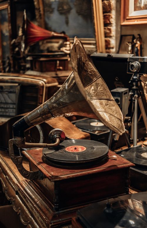 Free Classic gramophone with a vinyl record in an antique shop full of nostalgic items, capturing timeless elegance. Stock Photo