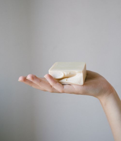 Free Close-up of a hand delicately holding a premium handcrafted soap bar, showcasing natural skincare. Stock Photo