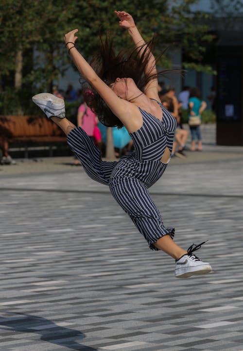 Woman in Black and White Stripe Shirt and Pants In A Bending Backward Position