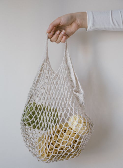 Photo of a Person's Hand Holding a Mesh Bag