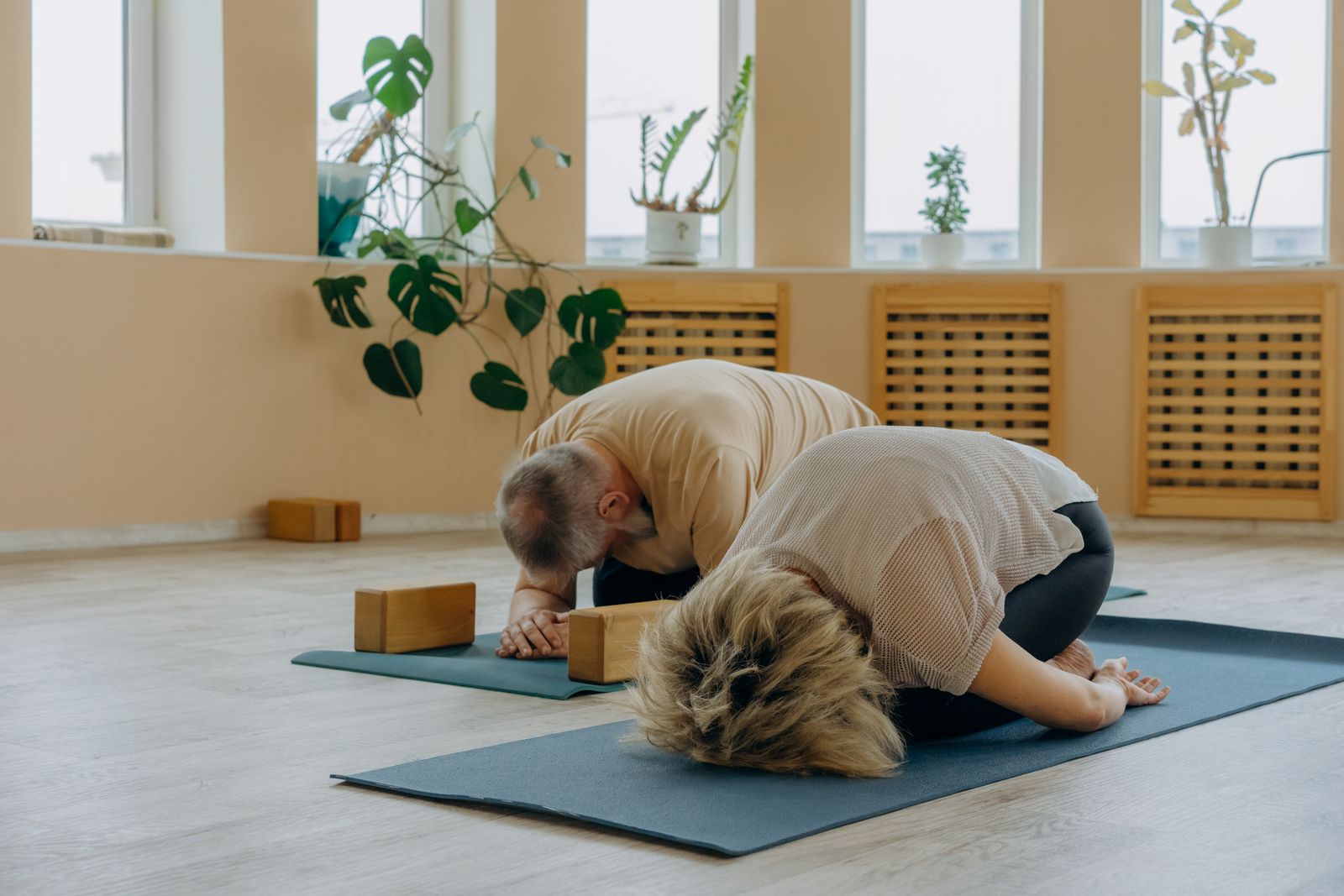 Senior couple practicing yoga together indoors for heart health and blood pressure management