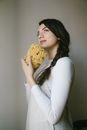 Woman in White Long Sleeve Shirt Holding Brown Bread