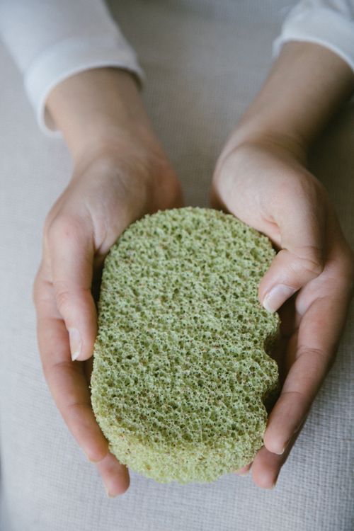 Free A pair of hands gently holding a green eco-friendly sponge, emphasizing sustainable self-care. Stock Photo