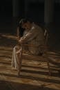 Man in Gray Hoodie Sitting on Brown Wooden Chair