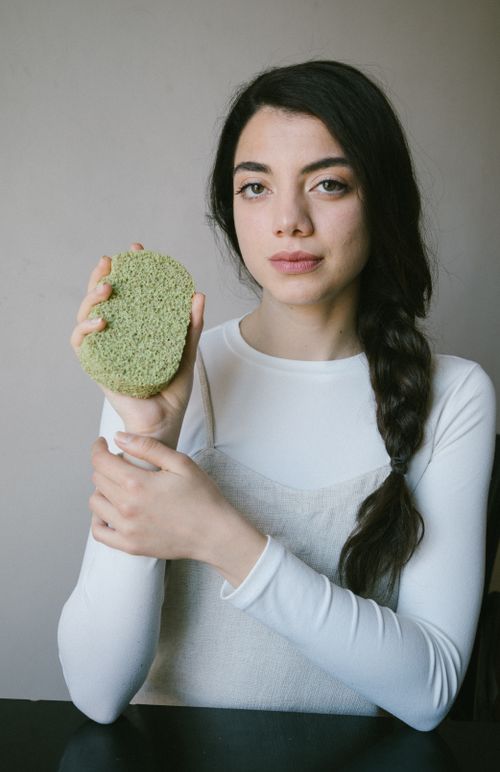 Free Woman holding eco-friendly sponge, highlighting natural skincare in Istanbul. Stock Photo
