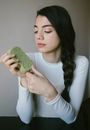 Woman in White Crew Neck Shirt Holding Green Fruit