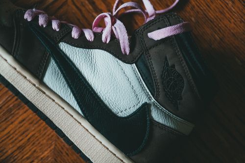 Free Top view of close up of modern black footwear with pink laces placed on wooden surface Stock Photo