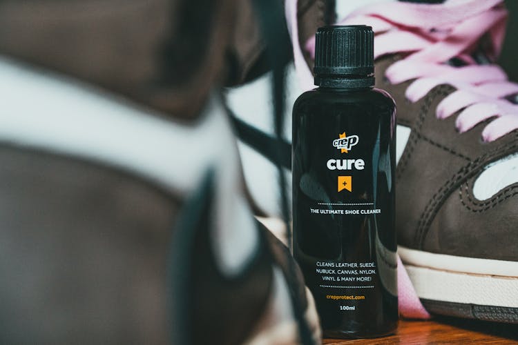 Bottle Of Shoes Care Product Between Fashion Sneakers