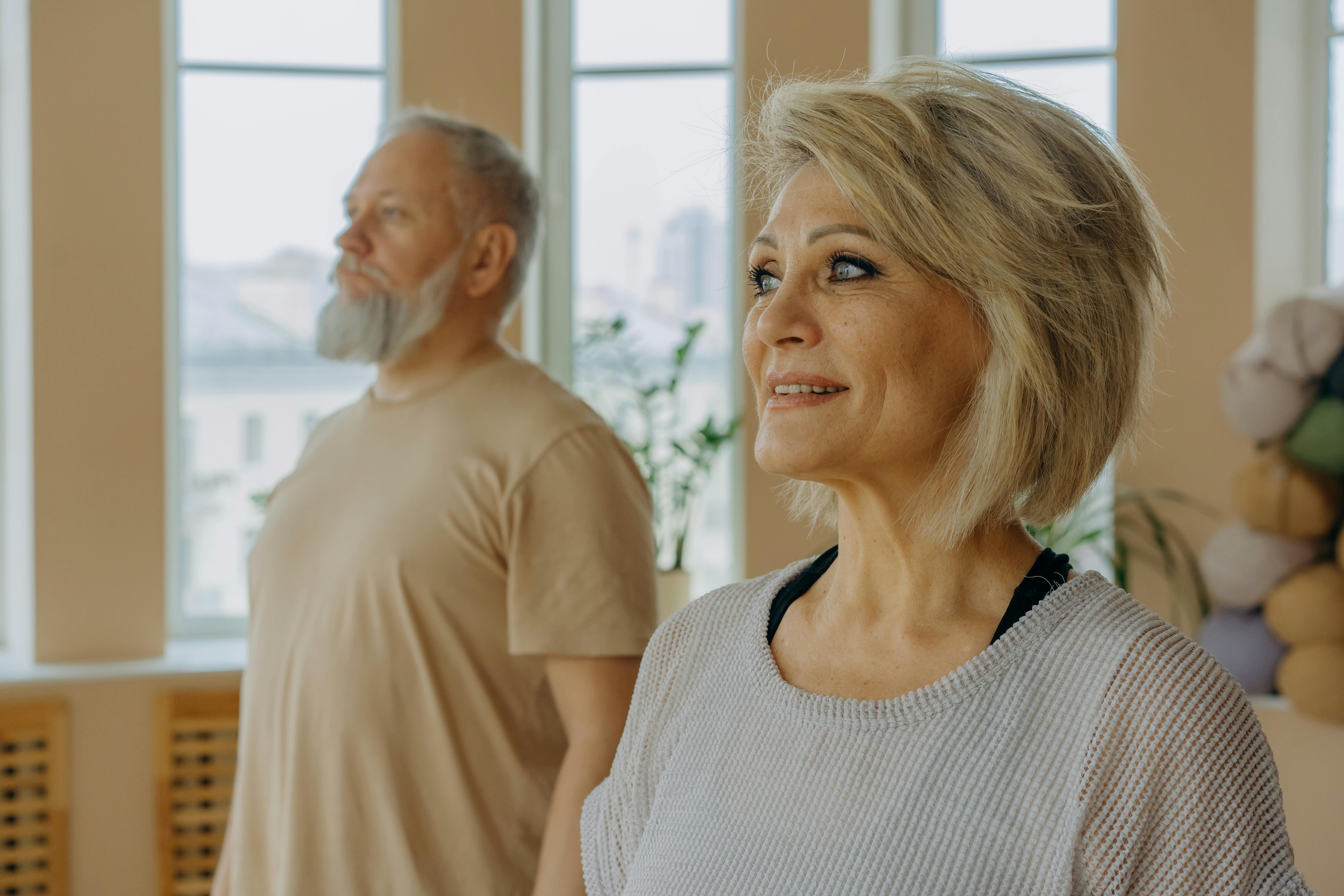 woman in white and black striped tank top standing beside man in beige crew neck t