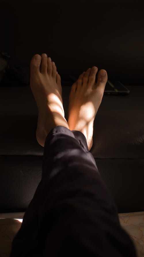 Human legs crossed in sunlight