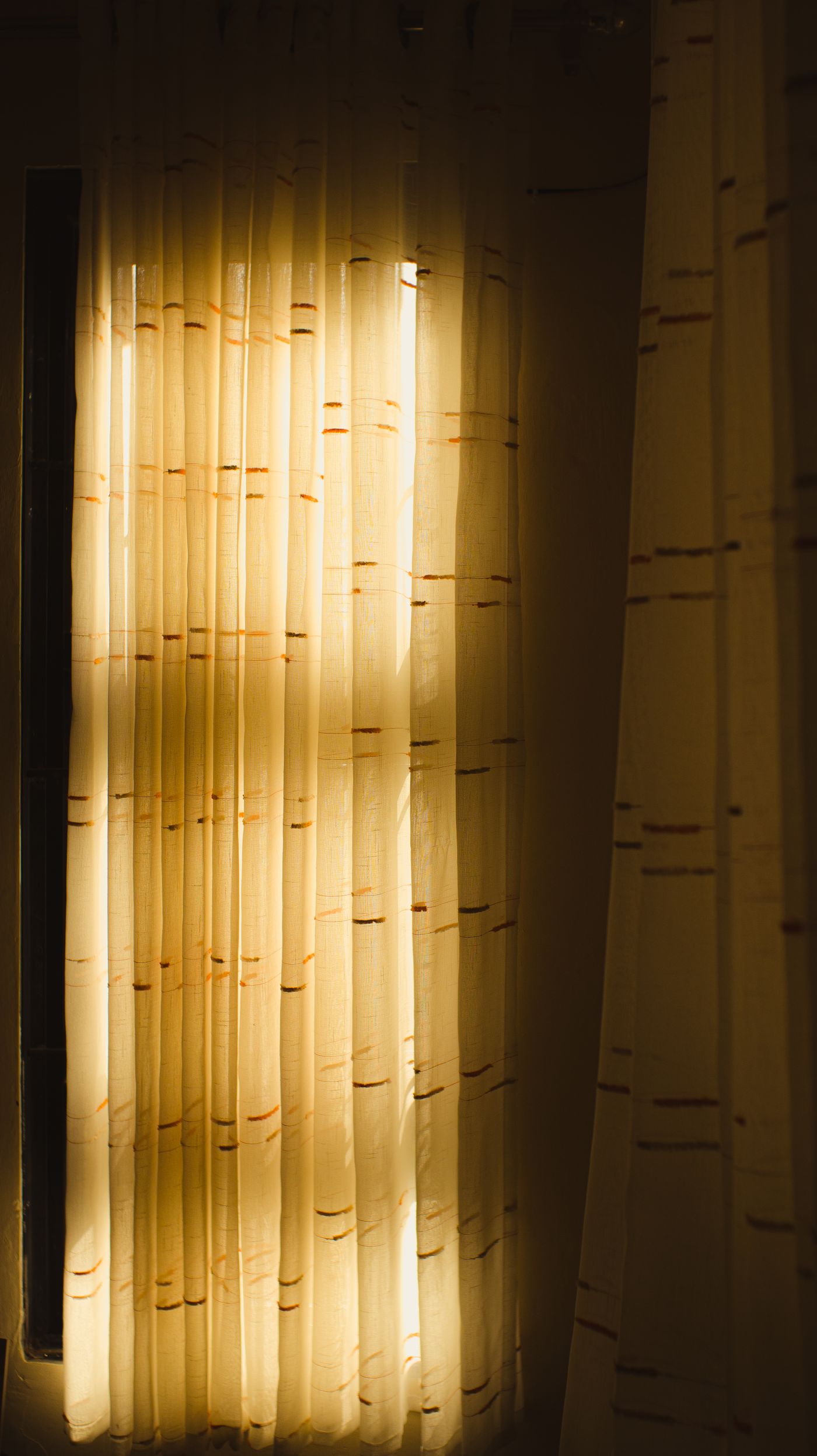 Sunlight passing through white sheer curtains