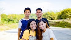 Multiracial smiling friends in street near plants