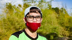 Young ethnic man in red protective mask