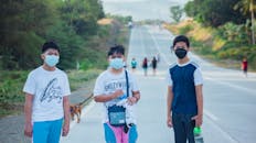 Group of Asian male teenagers walking on road