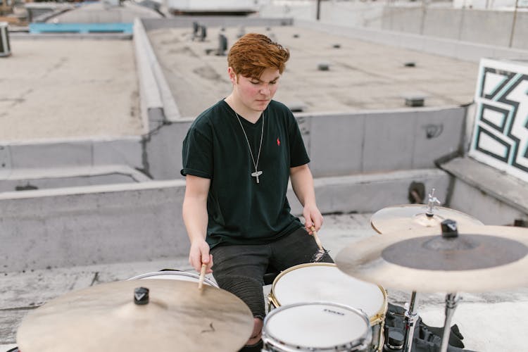 A Man In Black Shirt Playing Drums