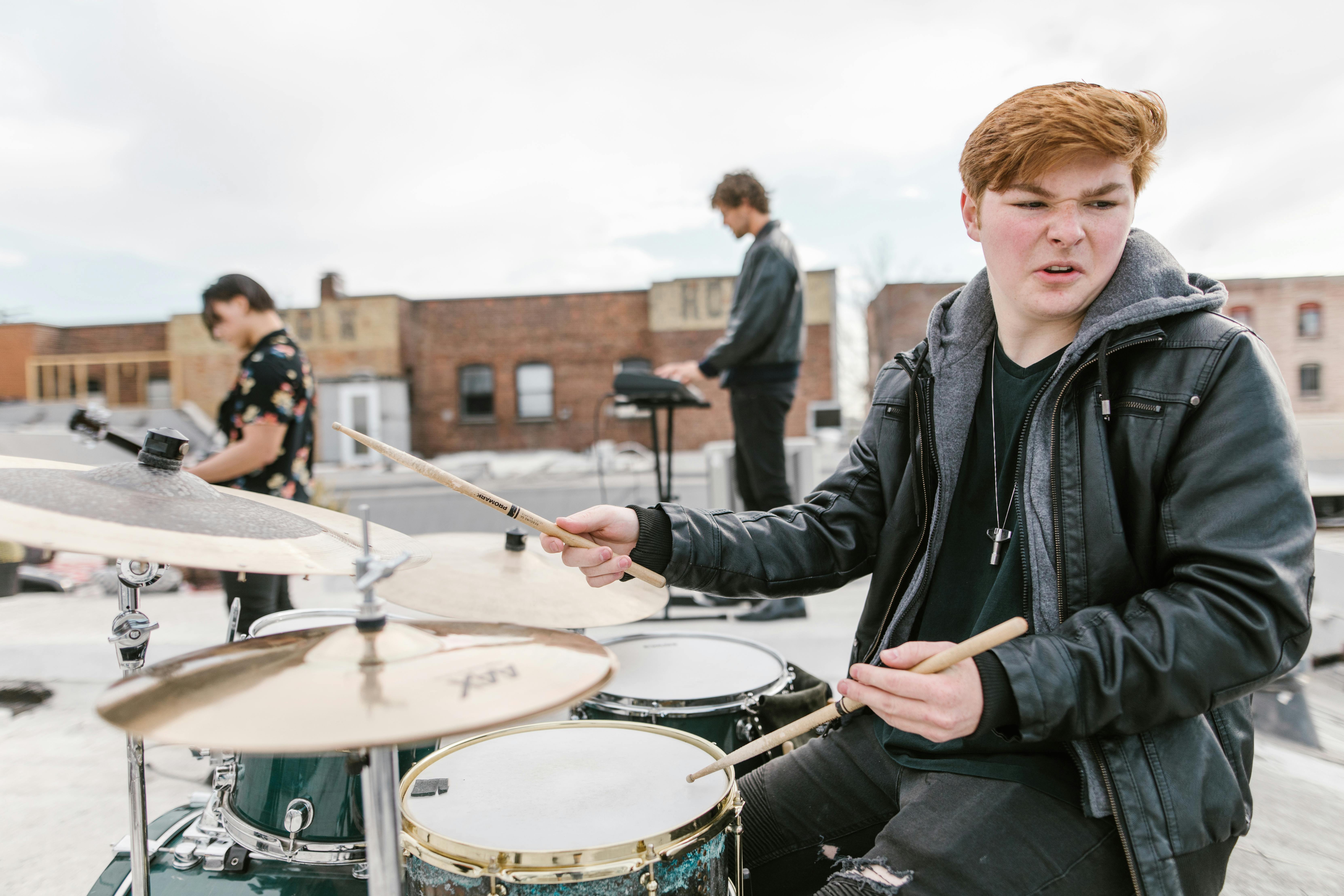 Man in Black Leather Jacket Playing Drum