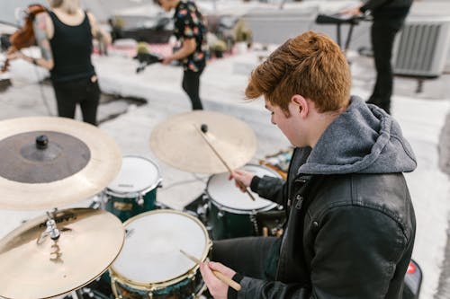 Man in Black Leather Jacket Playing Drum