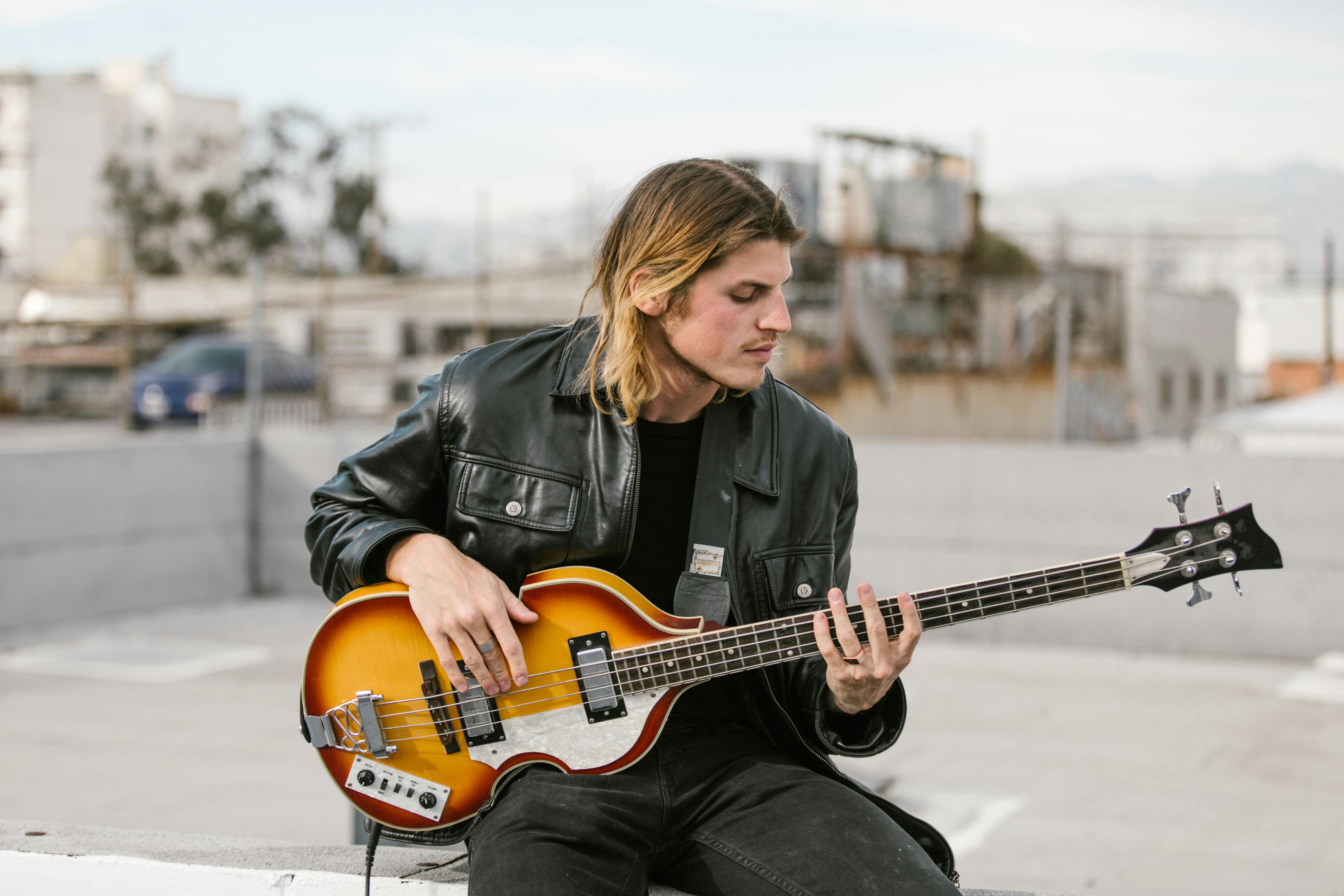 Man in Black Leather Jacket Playing Guitar