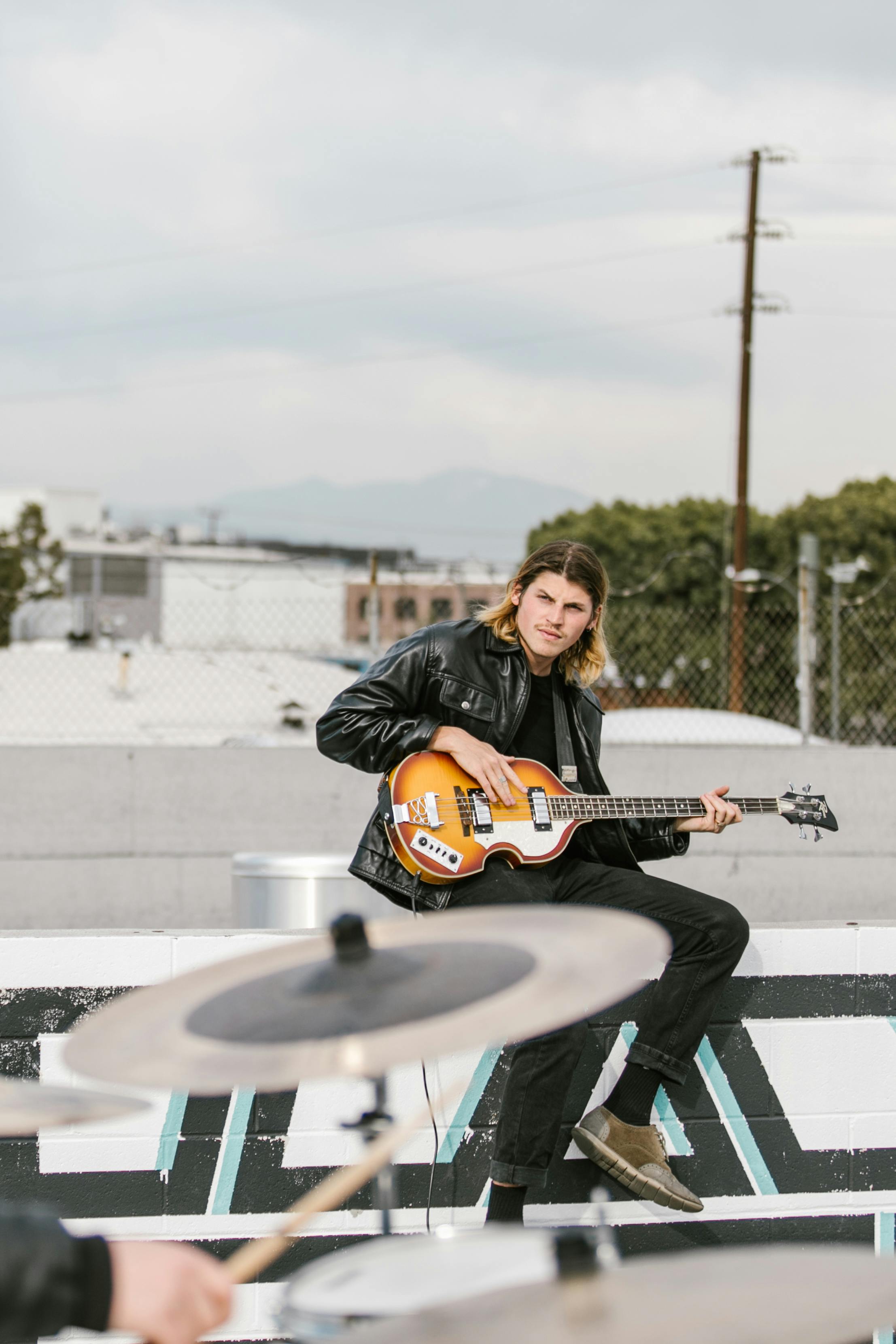 A Bassist Wearing a Leather Jacket During a Gig · Free Stock Photo