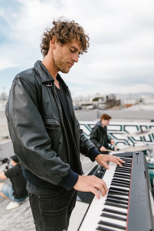 Man in Black Leather Jacket Playing Piano
