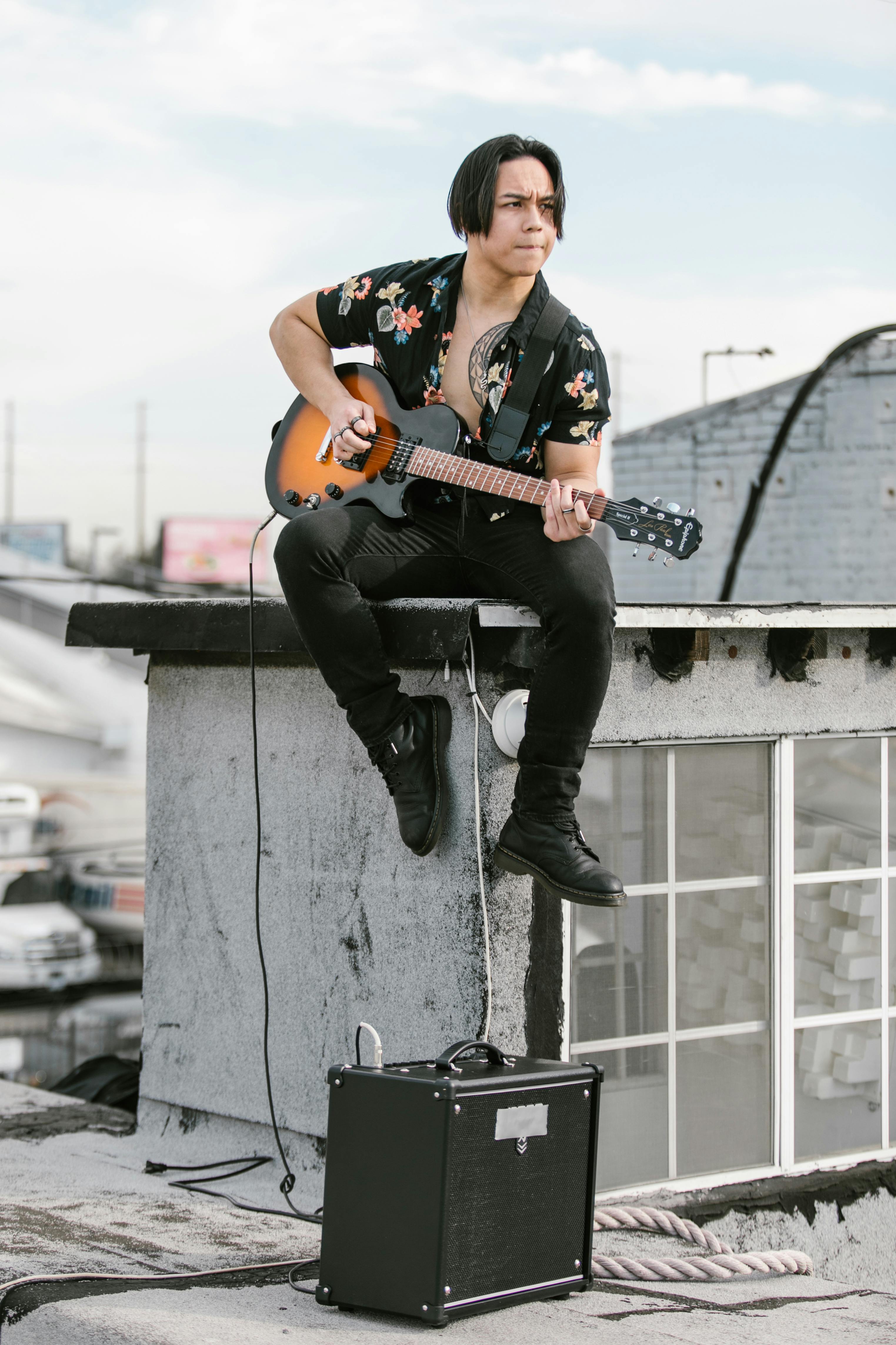 Man in Black and White Floral Shirt Playing Brown Electric Guitar