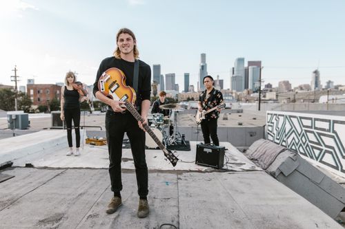 Free Band performing on rooftop with city skyline. Energetic urban music scene. Stock Photo