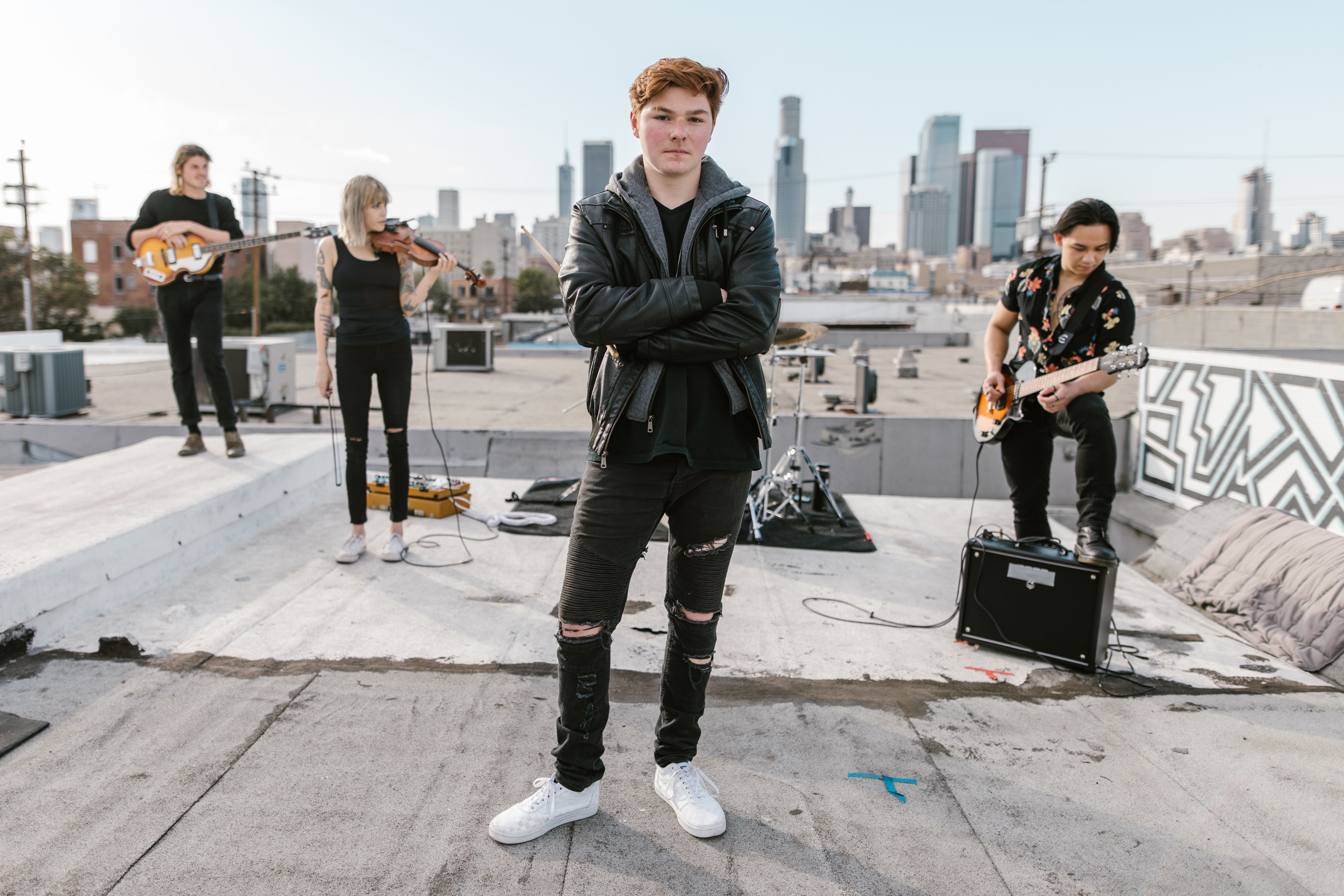 A teenager playing guitar on a rooftop at sunset, looking confident and inspired