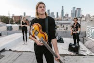 Man in Black Long Sleeves carrying an Electric Guitar