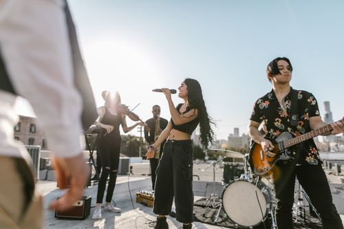 Free A diverse band performs outdoors at sunset, showcasing various musical instruments and talent. Stock Photo