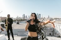 Woman in Black Crop Top and Black Denim Shorts Holding Blue and White Labeled Bottle