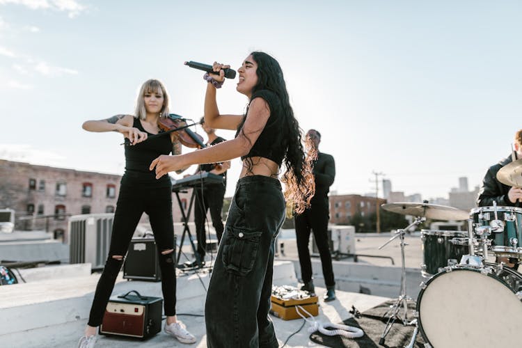 A Woman Violinist And Vocalist In A Rooftop Concert