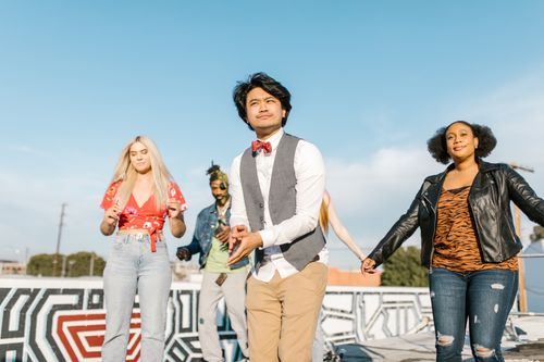 Free A diverse group of adults enjoying a sunny rooftop party, embracing fashion and togetherness. Stock Photo