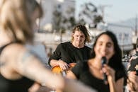 A Man in Black Long Sleeve Shirt Playing the Guitar