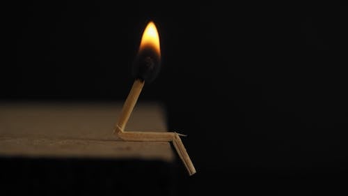 Free Lighted Matchstick on Brown Wooden Surface Stock Photo