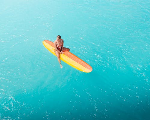 A Woman Sitting on a Surfboard