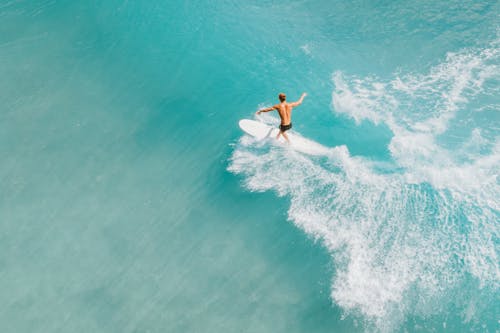 Surfer Surfing on Blue Ocean Water