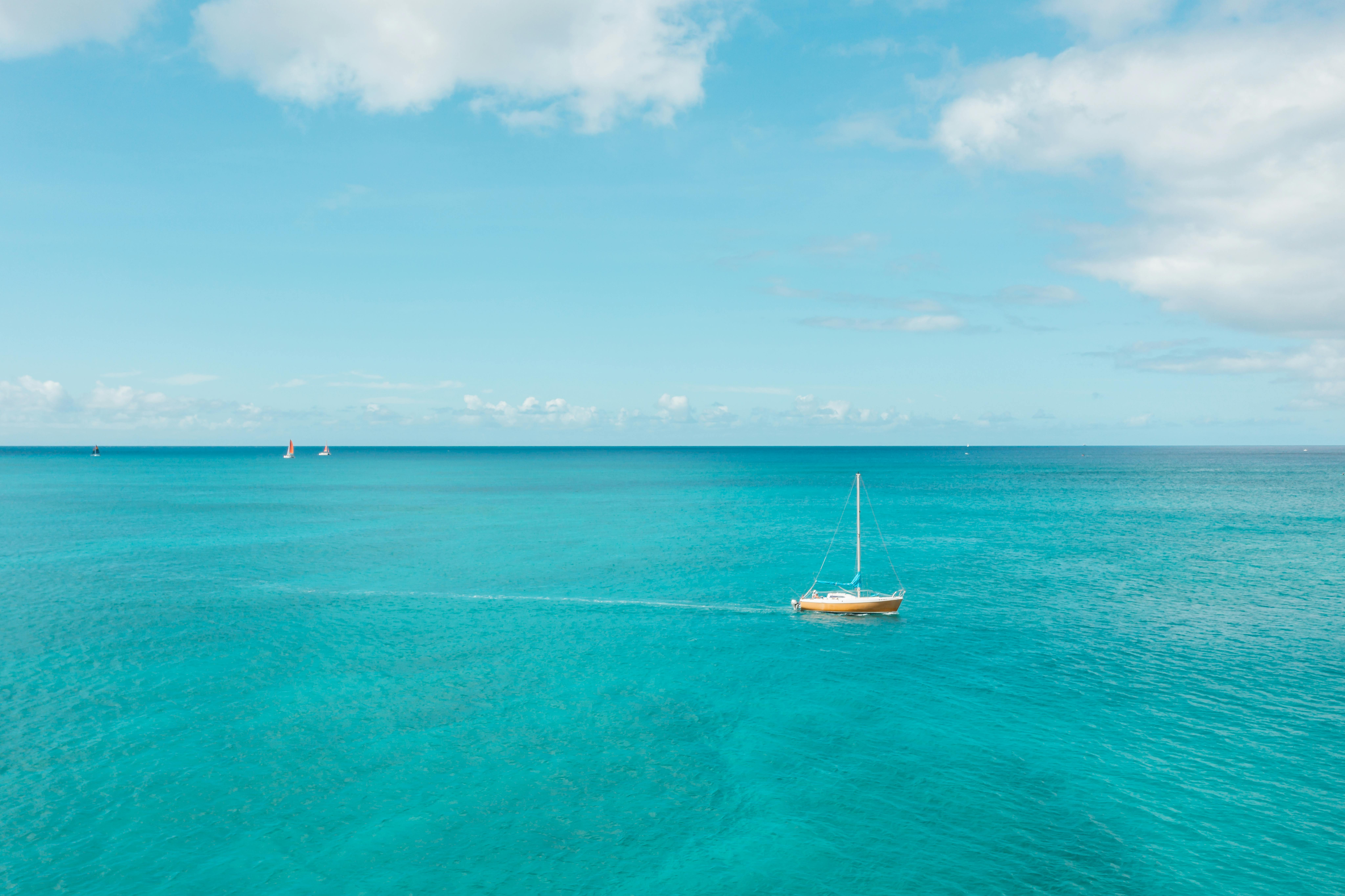 Voilier blanc naviguant sur la mer turquoise des Antilles sous un ciel bleu