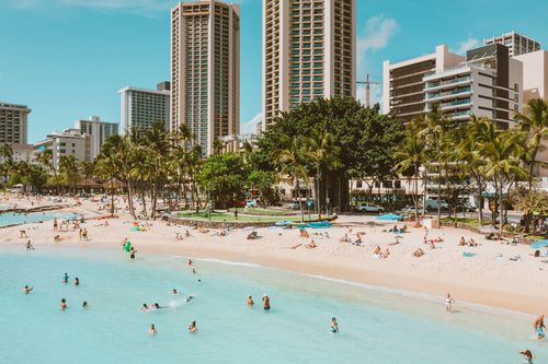 Free A vibrant beachfront scene in Honolulu with tourists enjoying the sun and sea. Stock Photo