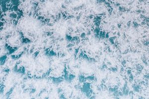 Aerial surf and sea foam. Photo by Jess Loiterton on Pexels