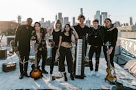 Young Band Posing Holding Music Instruments