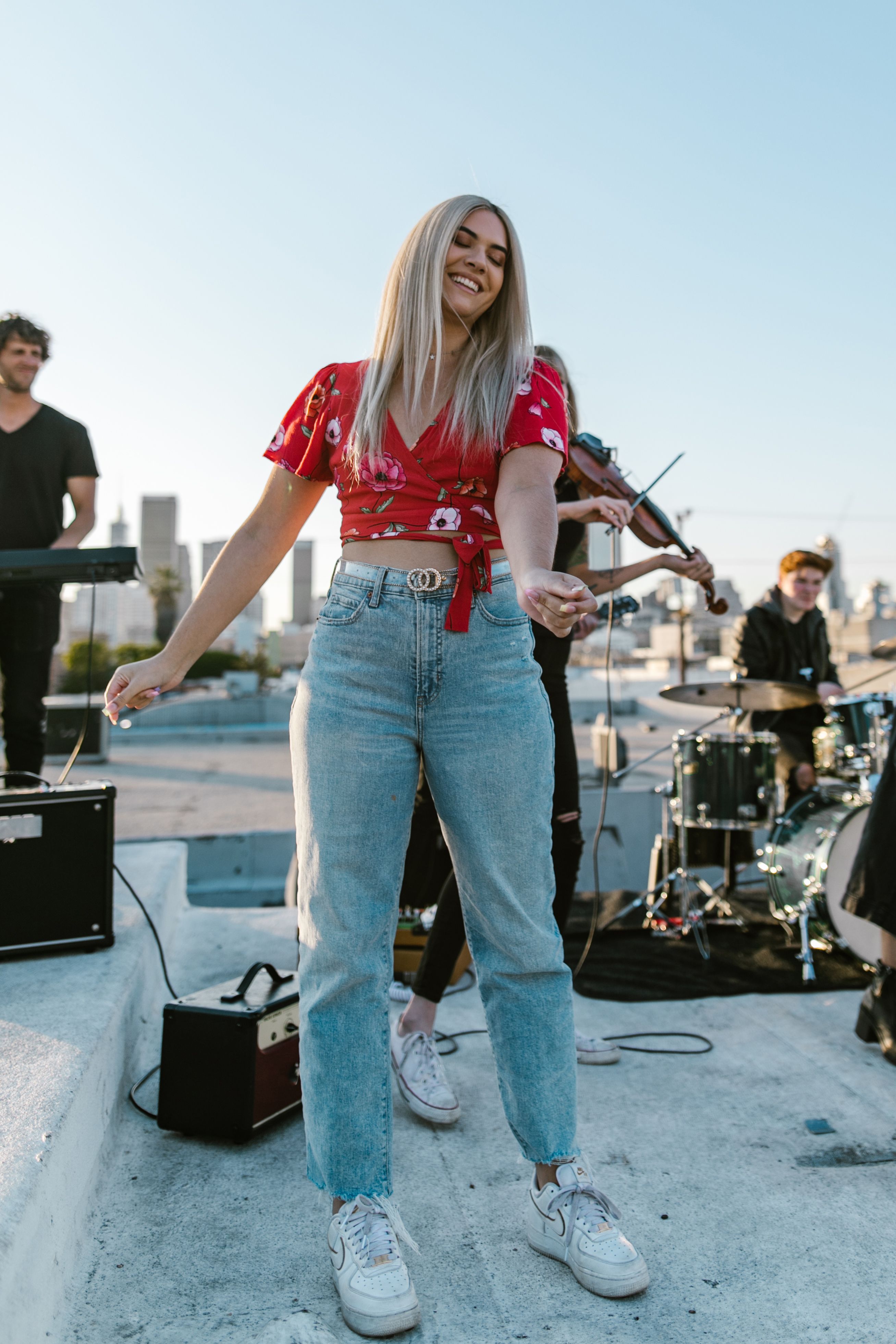 Woman dancing at outdoor band performance, lively and joyful atmosphere.