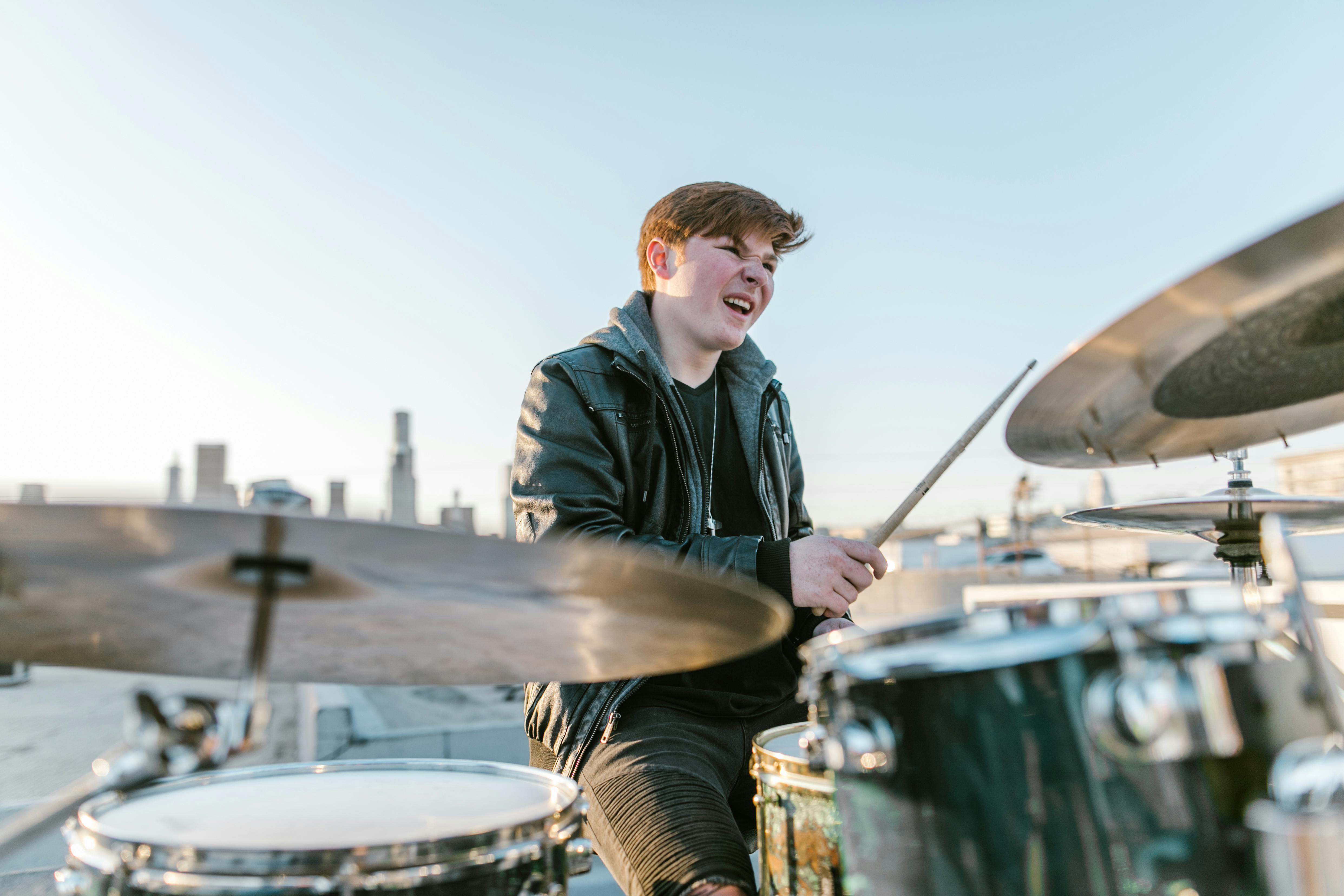 Man in Black Leather Jacket Playing Drum