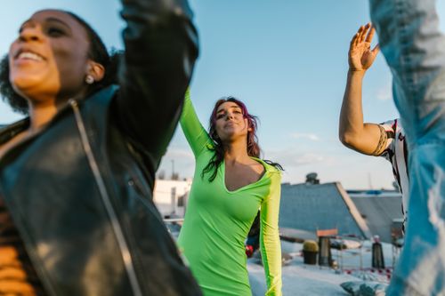 Free A diverse group enjoys a rooftop party, capturing joy and celebration under a clear blue sky. Stock Photo