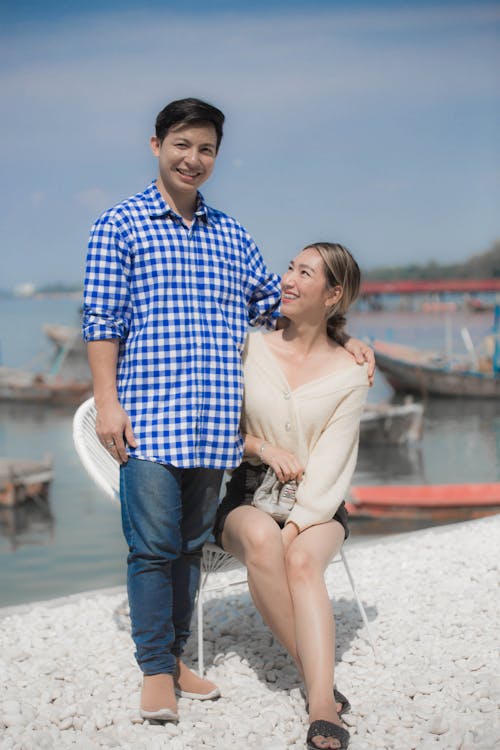 Photo of a Woman Sitting Beside a Man in a White and Blue Shirt