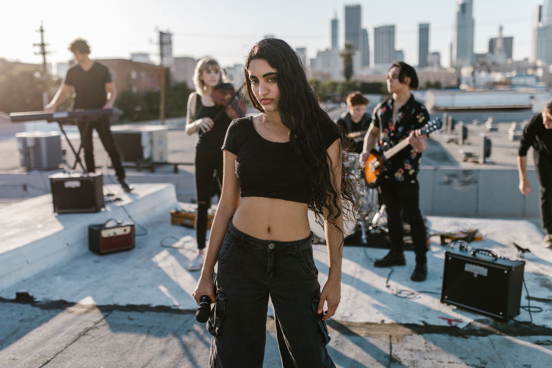 Photo of Woman in Black Crop Top and Band Performing on Rooftop