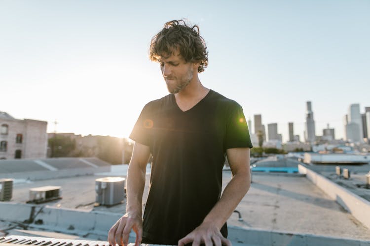 A Man In Black T-shirt Playing The Piano