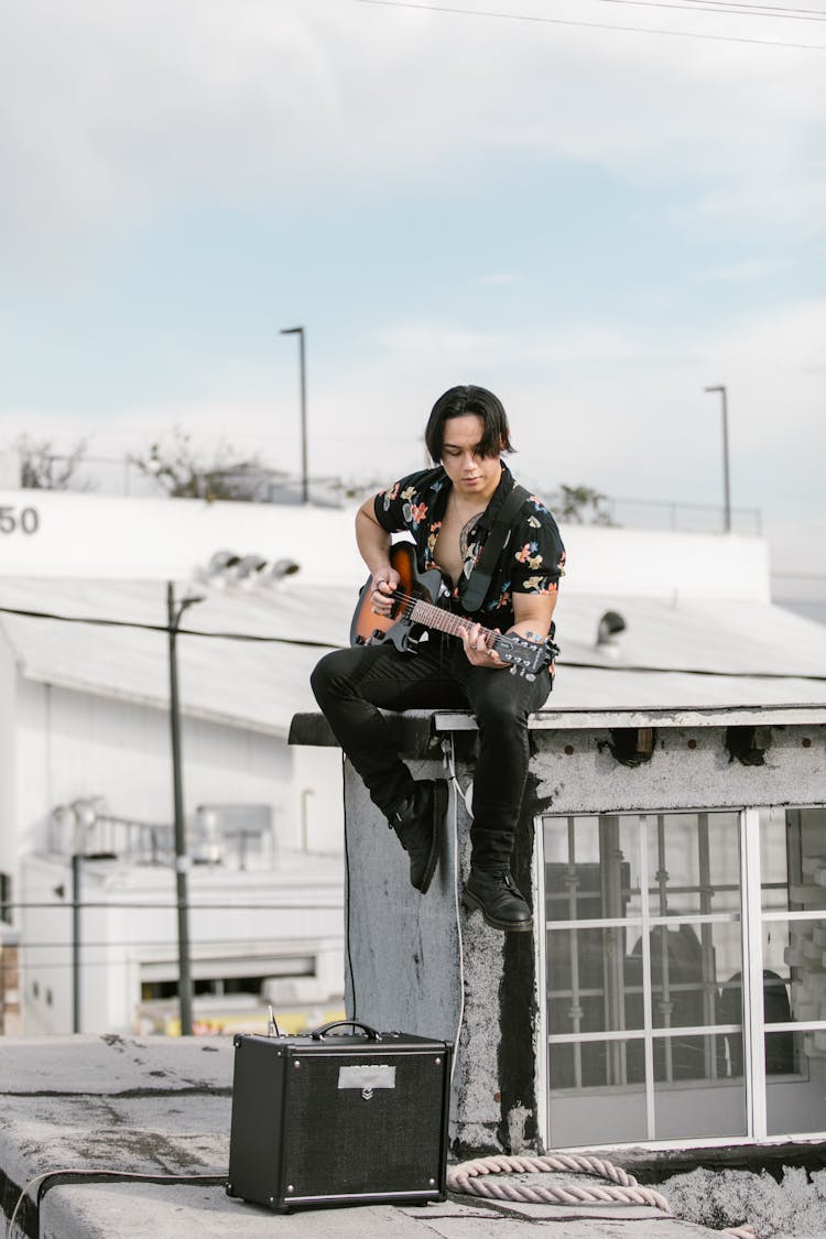 Man In Black Shirt Playing Guitar On The Rooftop