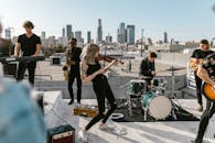 Woman Playing Violin on the Rooftop with Music Band
