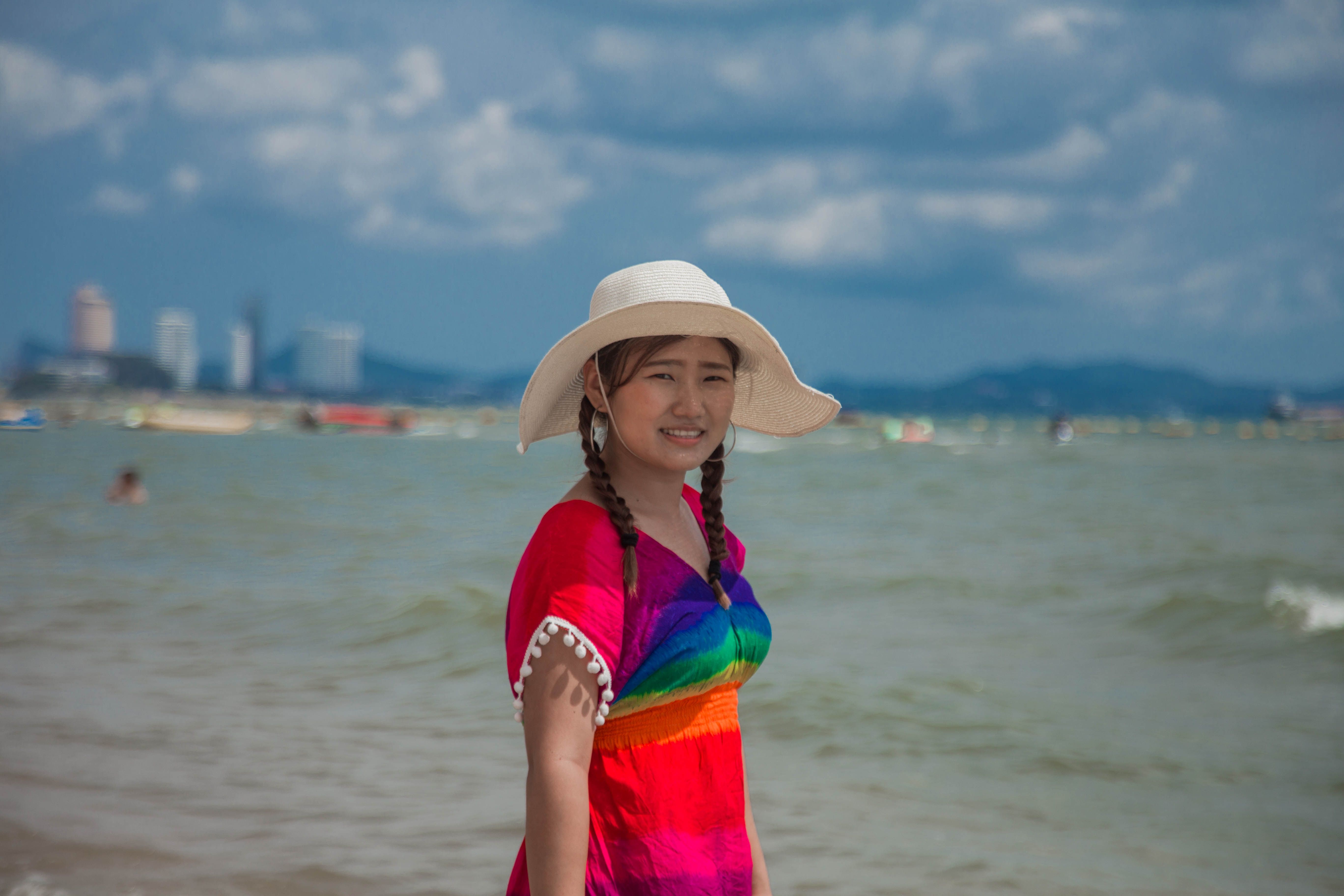 Girl in Hat and Bright Top Walking on the Beach · Free Stock Photo