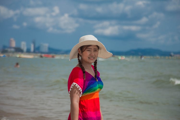 Girl In Hat Wearing Colorful Top Beside Water